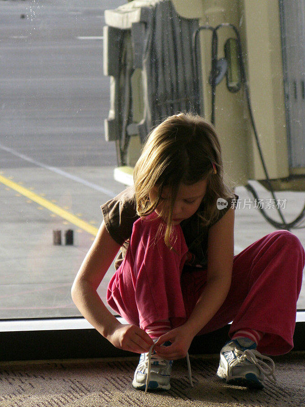 5-6 Year Old Girl Child Tying Sneakers at Airport Terminal